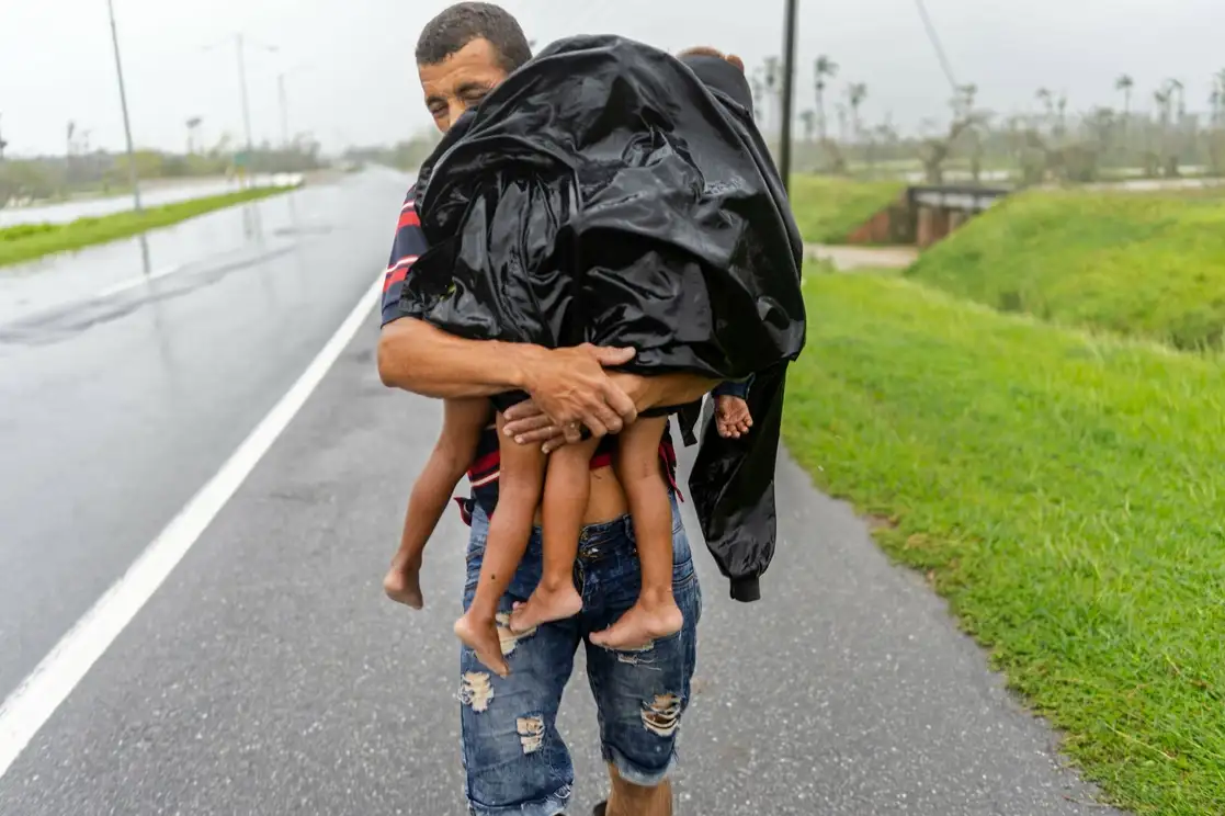 El embate del meteoro de categoría 3, con ráfagas de viento de 208 kilómetros por hora, provocó inundaciones, techos arrancados y árboles y postes de luz derribados. La región de Pinar del Río fue una de las más afectadas y unas 40 mil personas fueron desalojadas; las autoridades reportaron al menos dos fallecidos en esa provincia. En la imagen, un padre de familia busca refugio con dos de sus hijos. Al cierre de esta edición estaba previsto que el fenómeno impactara en la costa oeste de Florida. Foto Ap 