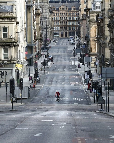 Un ciclista transita por una calle desierta, la Saint Vincent, en Glasgow, Escocia. Foto Ap
