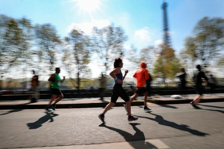 En esta fotografía de archivo tomada el 14 de abril de 2019, los atletas pasan junto a la Torre Eiffel en París, durante la 43a edición del Maratón de París. Foto Afp