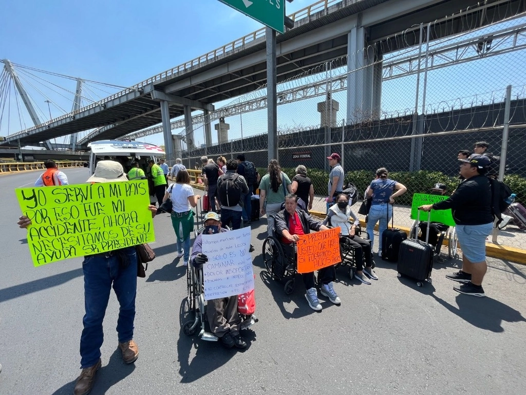 Personas en silla de ruedas bloquean el acceso principal a la Terminal 1 del Aeropuerto Internacional de la Ciudad de México, para exigir que el gobierno federal les ayude a recibir un tratamiento de células madre para la columna, el 24 de abril de 2023. Foto Alfredo Domínguez