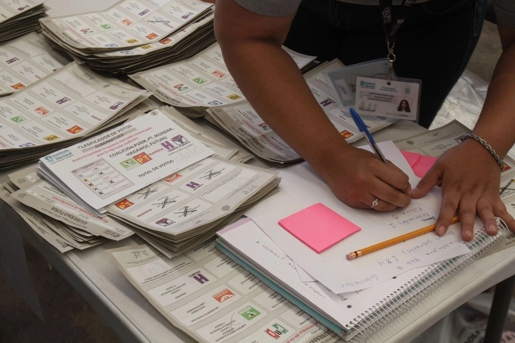 Personal del Instituto Electoral y de Participación Ciudadana de Jalisco, durante el conteo de votos realizado en la sede del consejo distrital 13, en San Pedro Tlaquepaque. Foto Arturo Campos Cedillo / Archivo