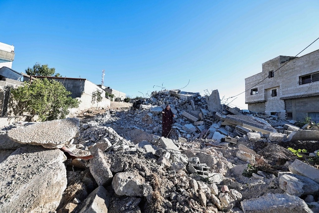 Mujer en medio de los restos de su casa demolida por el ejército israelí en Cisjordania. Foto Afp