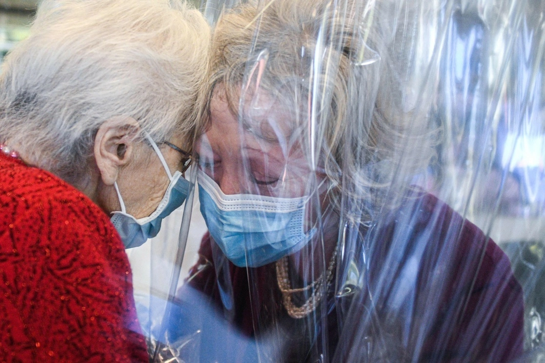 Dos mujeres se saludan en Veneto, Italia. Foto Afp
