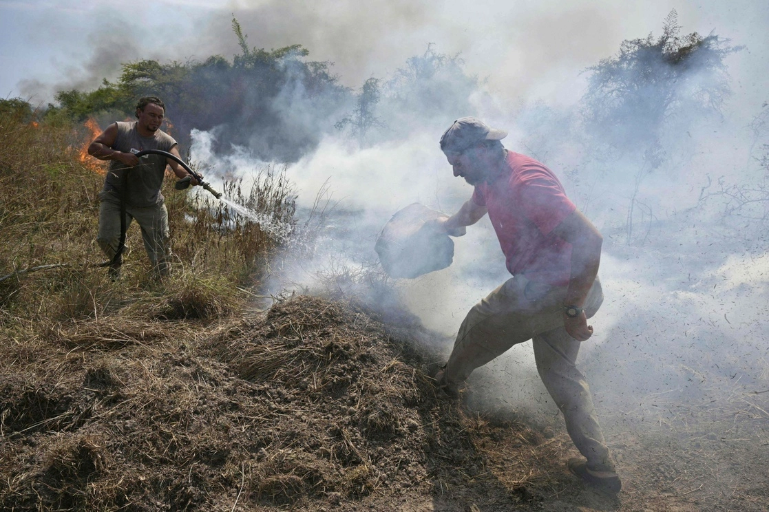 Casi 800 mil hectáreas están consumidas por incendios forestales que han destruido más de 9 por ciento de la provincia de Corrientes. En la imagen, voluntarios combaten el fuego que persiste desde diciembre en los secos pastizales de la región. Foto Afp

