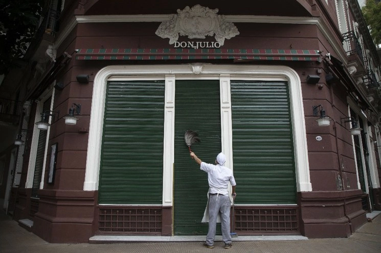 Limpieza externa a un comercio cerrado por la pandemia en Buenos Aires, Argentina. Foto Xinhua