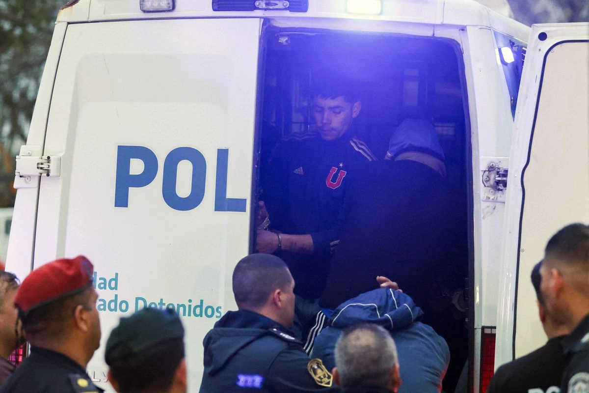 Tras ser detenidos, aficionados de la Universidad de Chile suben a un vehículo policiaco para ser trasladados a una comisaría en Avellaneda, provincia de Buenos Aires, el 21 de agosto de 2025. Foto 