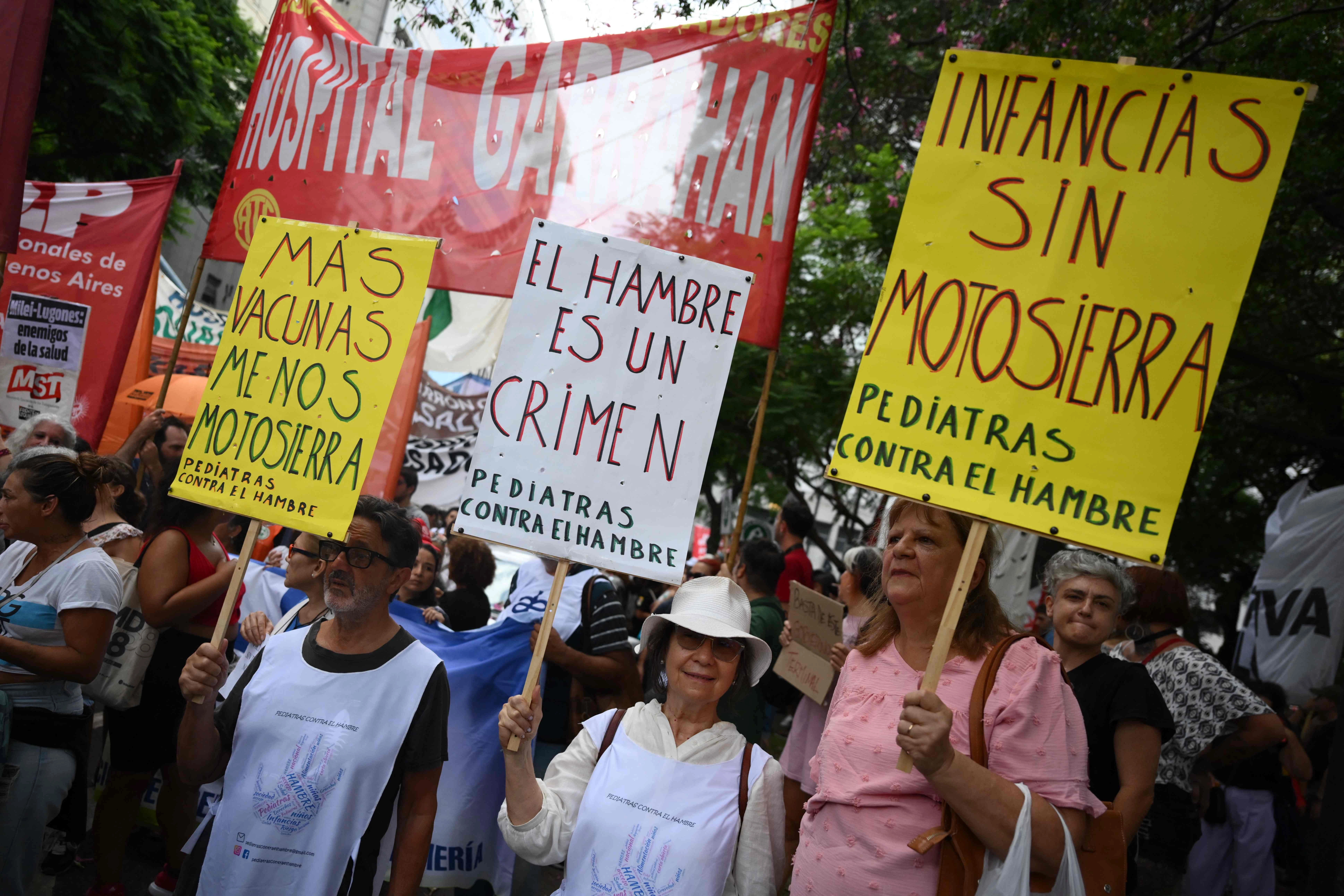 Trabajadores de la salud sostienen carteles contra la falta de presupuesto, incluso para vacunas, durante una protesta en Buenos Aires. Foto