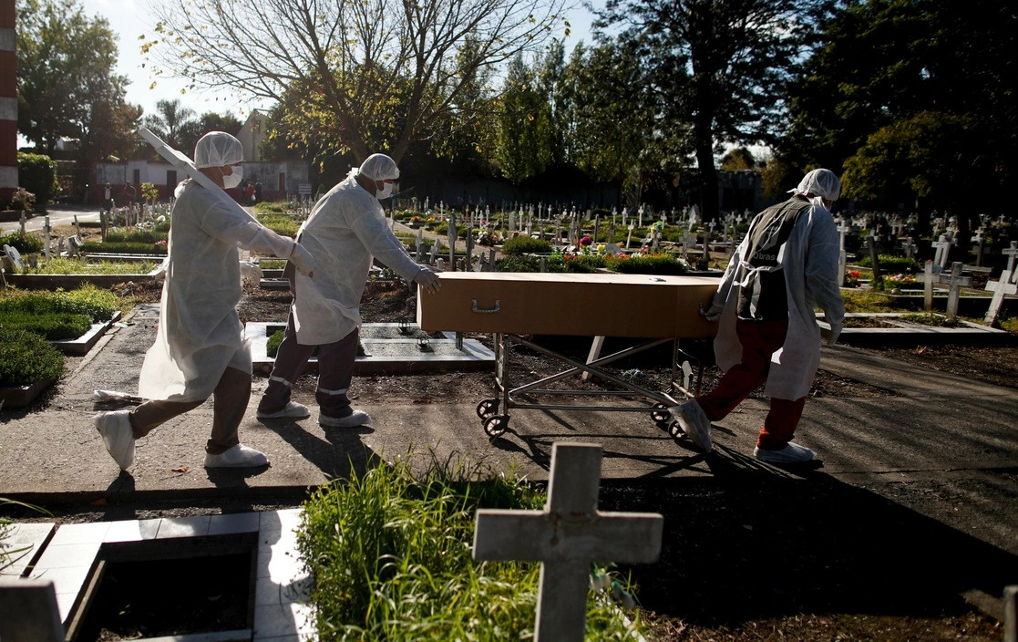Trabajadores de un cementerio en Buenos Aires llevan a enterrar a una persona que falleció de Covid-19. Foto Ap