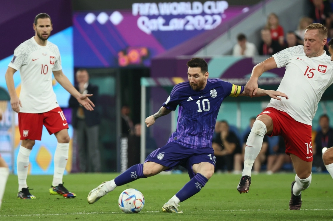 Lionel Messi conduce el balón ante dos jugadores de Polonia en el último juego del Grupo C, el cual ganó la ‘Albiceleste’ por 2-0, en el estadio 974 en Doha. Foto Xinhua