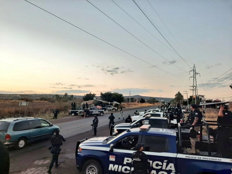 Policías de Michoacán vigilan la carretera Buenavista-Apatzingán, ayer, durante el operativo donde también decomisaron 15 armas largas, cargadores y equipo táctico en la tenencia Felipe Carrillo Puerto, conocida como La Ruana, en la región de la Tierra Caliente. Foto ‘La Jornada’