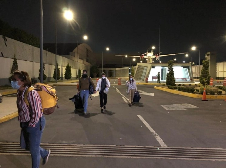 El avión aterrizó 9:50 de la noche, poco más de 20 minutos después salieron los primeros pasajeros quienes portaron cubrebocas. Foto Jessica Xantomila