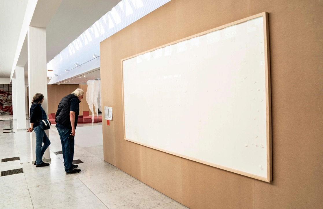 Gente se para frente a un marco vacío expuesto en el Museo Kunsten en Aalborg, Dinamarca, titulado 'Toma el dinero y corre' del artista Jens Haaning, el 28 de septiembre de 2021. Foto Afp