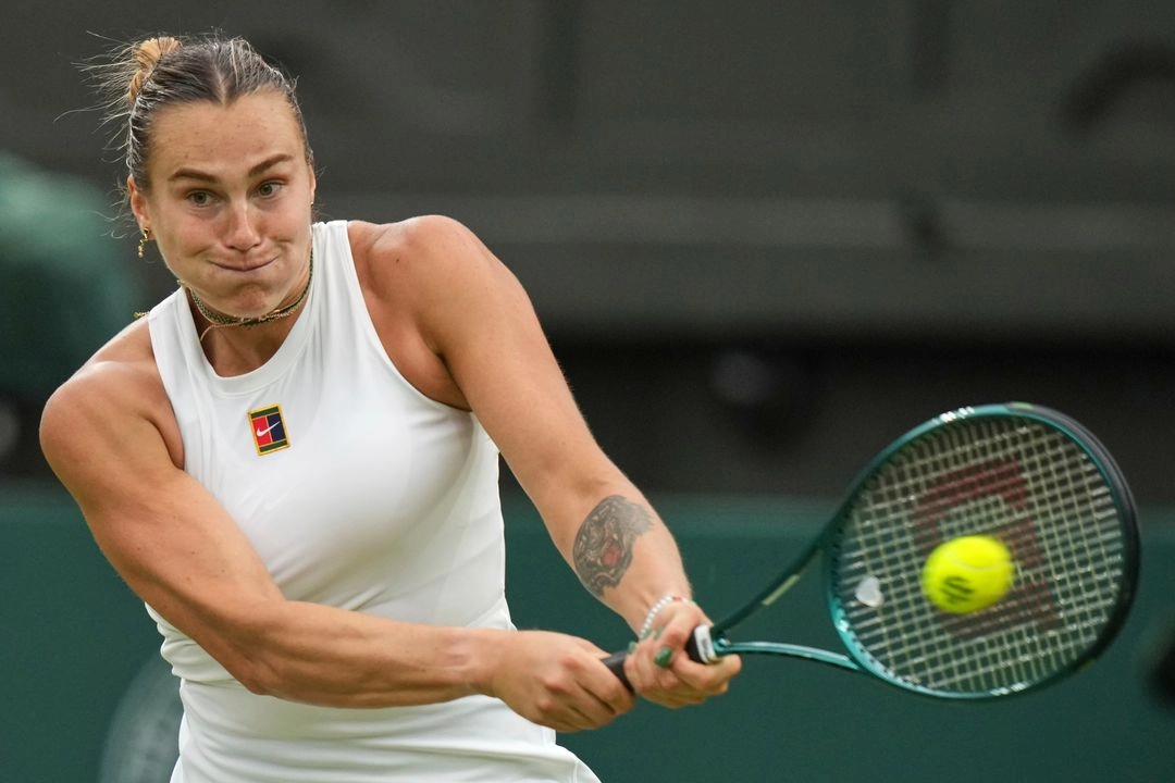 La bielorrusa Aryna Sabalenka devuelve un golpe ante la belga Elise Mertens durante un partido de cuarta ronda en Wimbledon, en Londres, el 6 de julio de 2025. Foto
