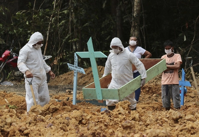 Trabajadores del cementerio ‘Nossa Senhora Aparecida’ en Manaos, Amazonas entierran el cuerpo de una mujer fallecida por Covid-19. Foto Ap
