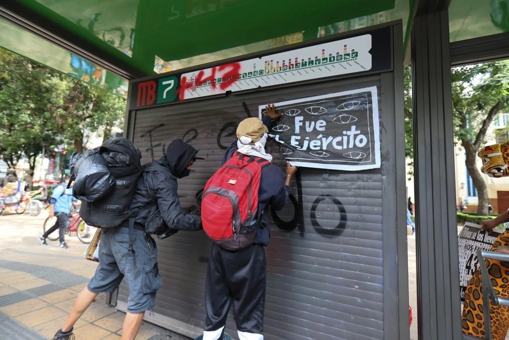 Manifestantes pegan carteles y realizan pintas sobre una estación del Metrobús en Paseo de la Reforma durante la marcha por el octavo aniversario de la desaparición de los 43 estudiantes de Ayotzinapa, el 26 de septiembre de 2022. Foto Pablo Ramos