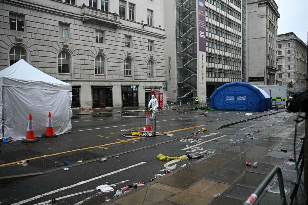 Un agente forense de la policía trabaja en el lugar de los hechos, en Water Street, Liverpool, noroeste de Inglaterra, donde un coche atropelló a la multitud que se había reunido por el trofeo de la Premier League de Liverpool. 