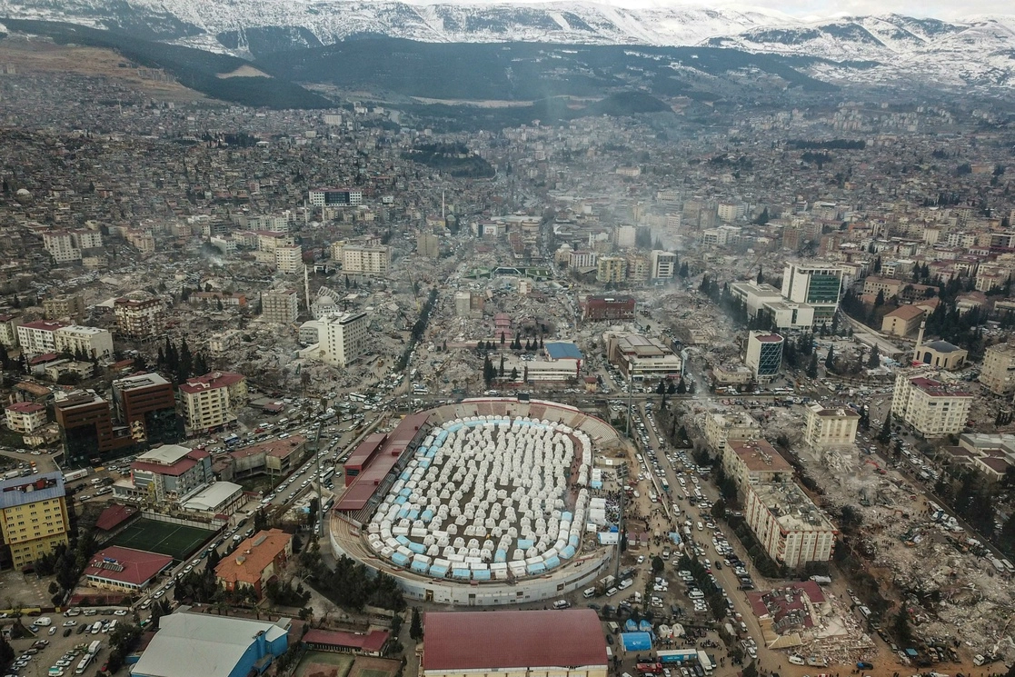 Vista aérea de la ciudad turca de Kahramanmaras, tras el sismo de magnitud 7.8 que azotó al país el pasado 6 de febrero. En la parte inferior se observa un campamento para los damnificados del sismo en el terreno ocupado por el estadio de la ciudad. Foto Afp.