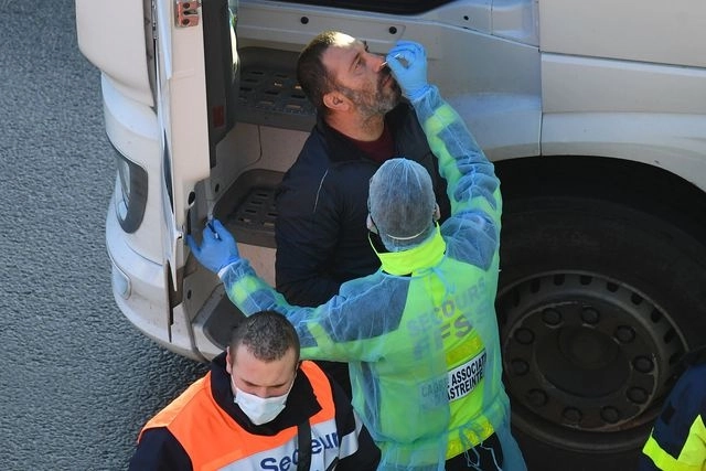 Personal médico de Francia realiza pruebas de detección de Covid-19 a transportistas cerca del puerto inglés de Dover. Foto Afp