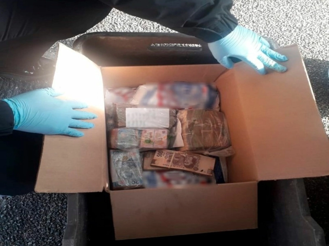 Elementos de la Guardia Nacional (GN) aseguraron 551 mil 980 pesos en efectivo que estaban ocultos entre bolsas de detergente y una mochila, por lo que detuvieron a dos personas en Oaxaca. Foto cortesía GN