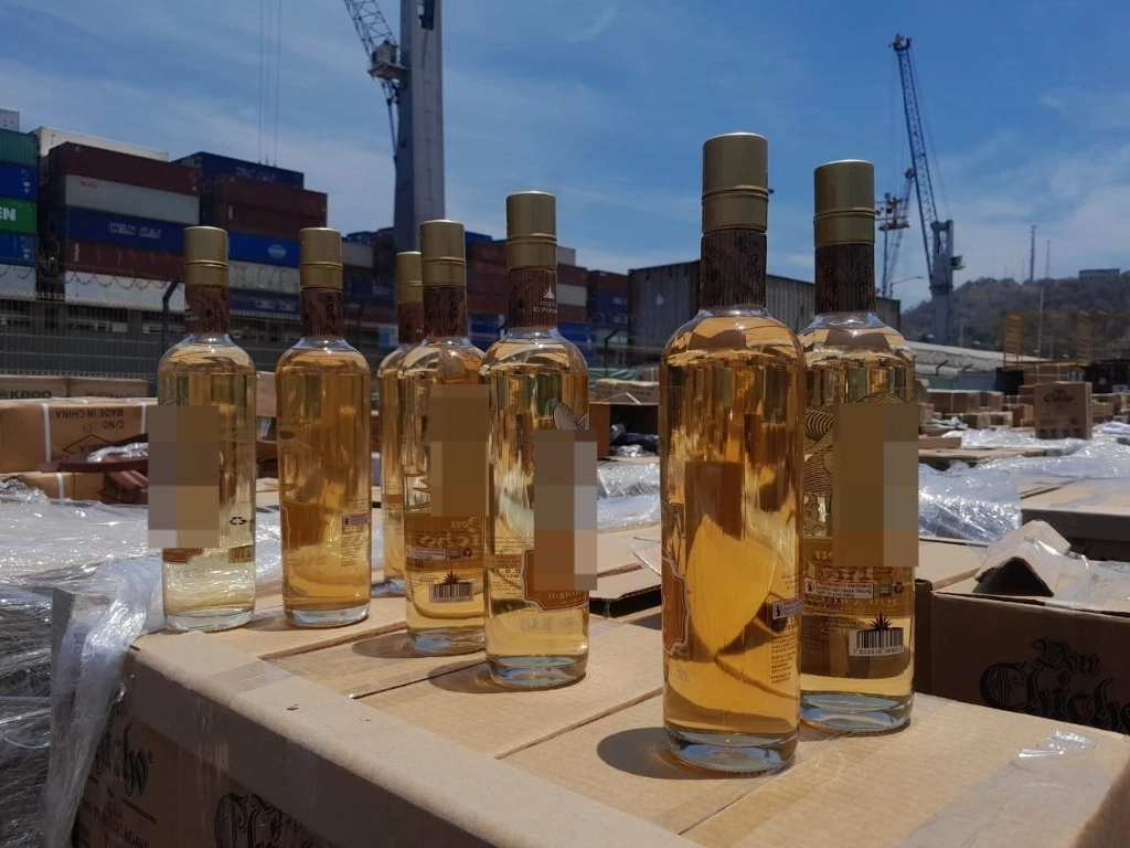 Un binomio canino de la Armada indicó como sospechoso un contenedor de carga que contenía 960 cajas con un total de 11 mil 520 botellas de tequila, por lo que el líquido que contenían fue objeto de un análisis con un sistema de identificación química, que confirmó la presencia de la droga. Imagen cortesía de Semar 
