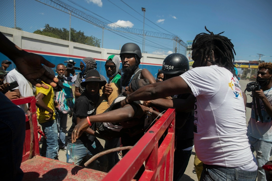 El periodista Lazard Maximilien es subido a una camioneta luego de ser herido en una protesta de obreros en Puerto Príncipe, Haití. Foto Ap