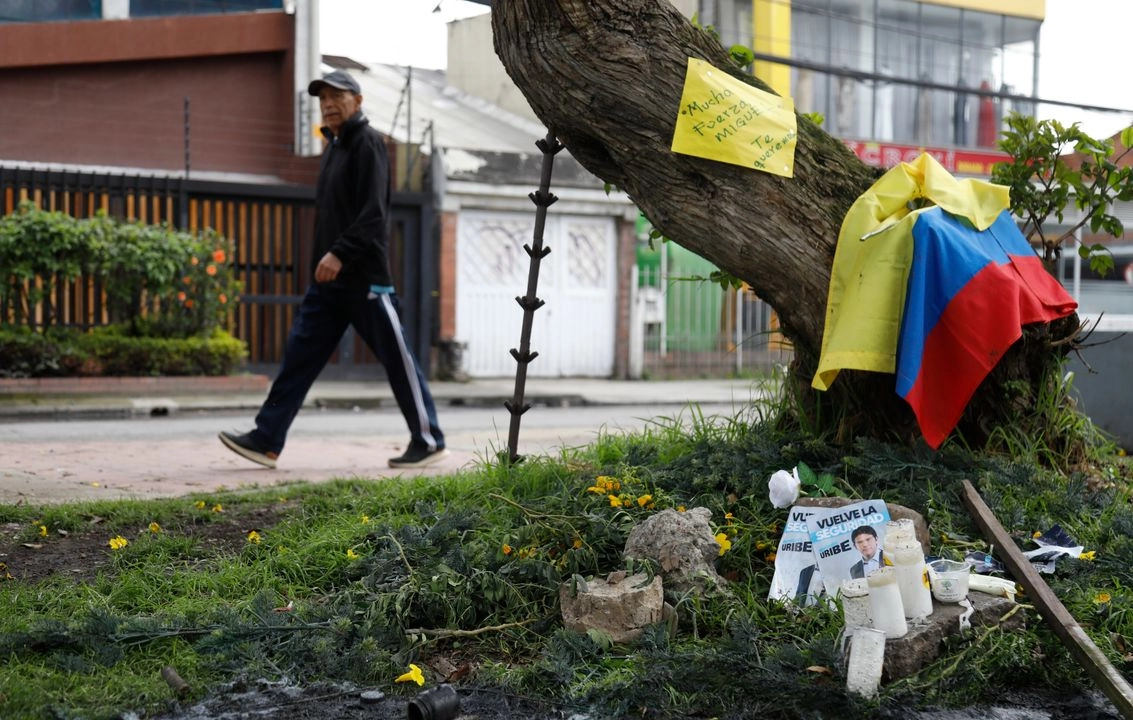 Imágenes del senador colombiano Miguel Uribe Turbay, junto con velas y una bandera, se encuentran en el lugar donde recibió un disparo durante un mitin político en Bogotá, Colombia, el lunes 9 de junio de 2025. Foto
