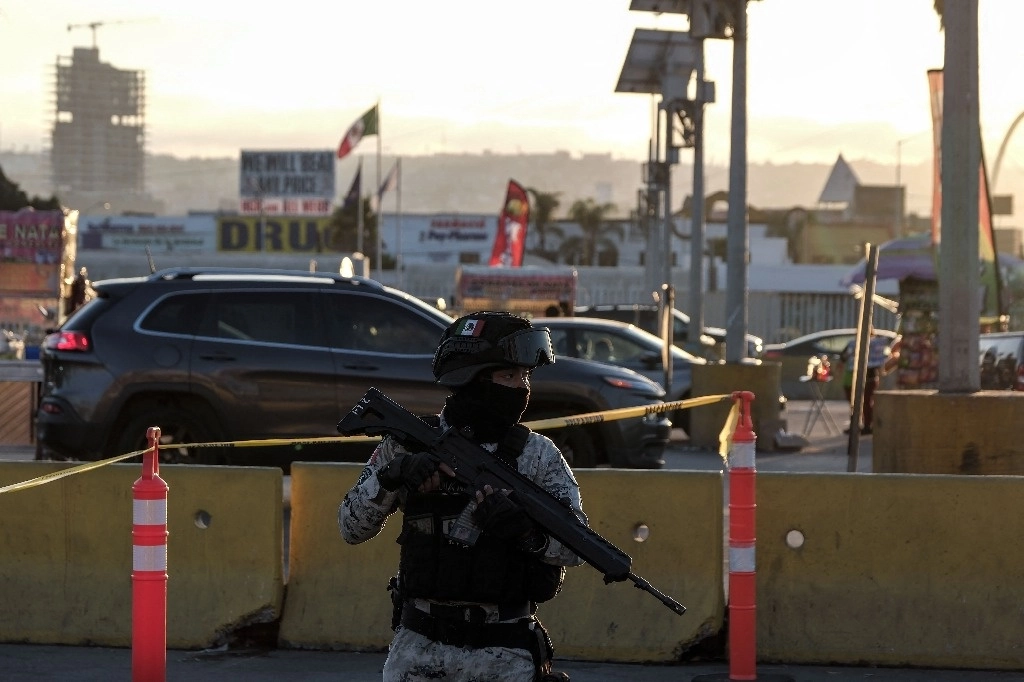 Refuerzan seguridad nacional en cruce de Tijuana. Un elemento de la Guardia Nacional revisa vehículos en el puente de San Ysidro, en la frontera con Tijuana, Baja California, antes de que crucen a Estados Unidos, como parte de un plan piloto para reforzar la seguridad del lado mexicano. Foto Afp