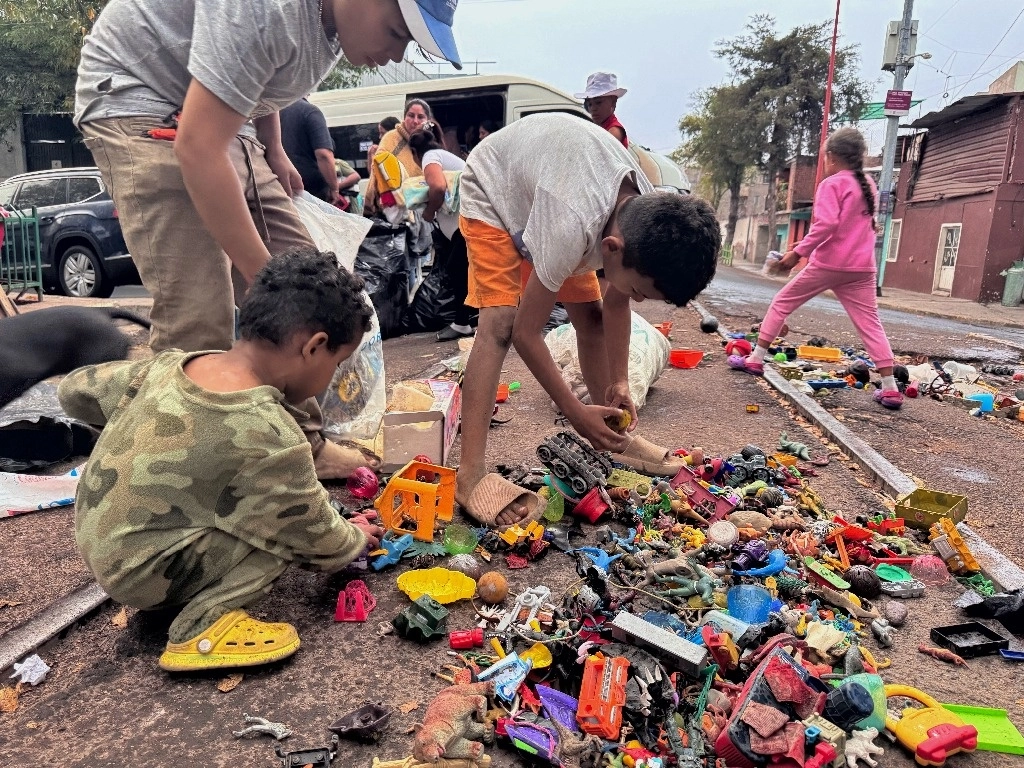 Por el Día de Reyes, grupos de apoyo a personas en tránsito entregaron ayer juguetes y ropa a los migrantes que permanecen en el campamento de Caruso, en la alcaldía Gustavo A. Madero. Foto Marco Peláez 
