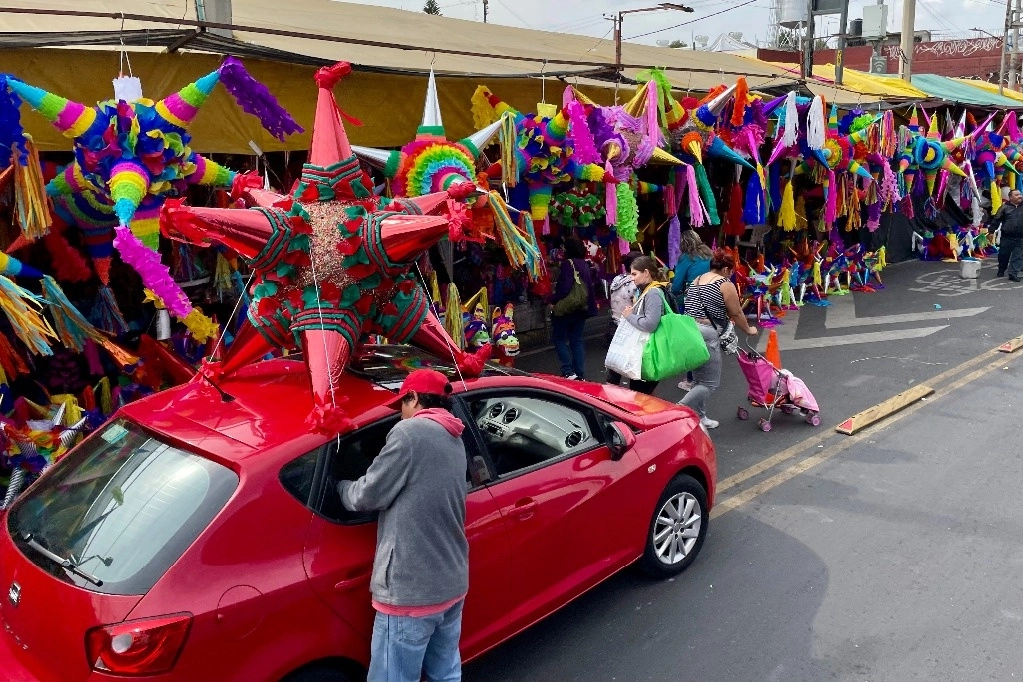 Capitalinos, en modo navideño. A poco menos de una semana del comienzo de las posadas, la gente acude ya a comprar sus piñatas a mercados como el de Jamaica (en la imagen). Foto Roberto García Ortiz 