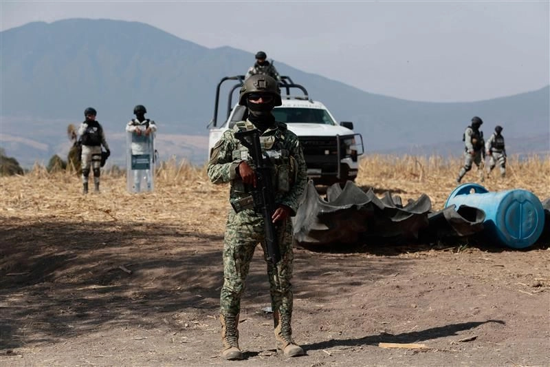 Soldados del Ejército Mexicano hacen guardia mientras personal de la Fiscalía General de la República inspecciona un predio de la comunidad de La Vega, en el municipio de Teuchitlán, Jalisco, en busca de indicios de actos criminales. Foto 