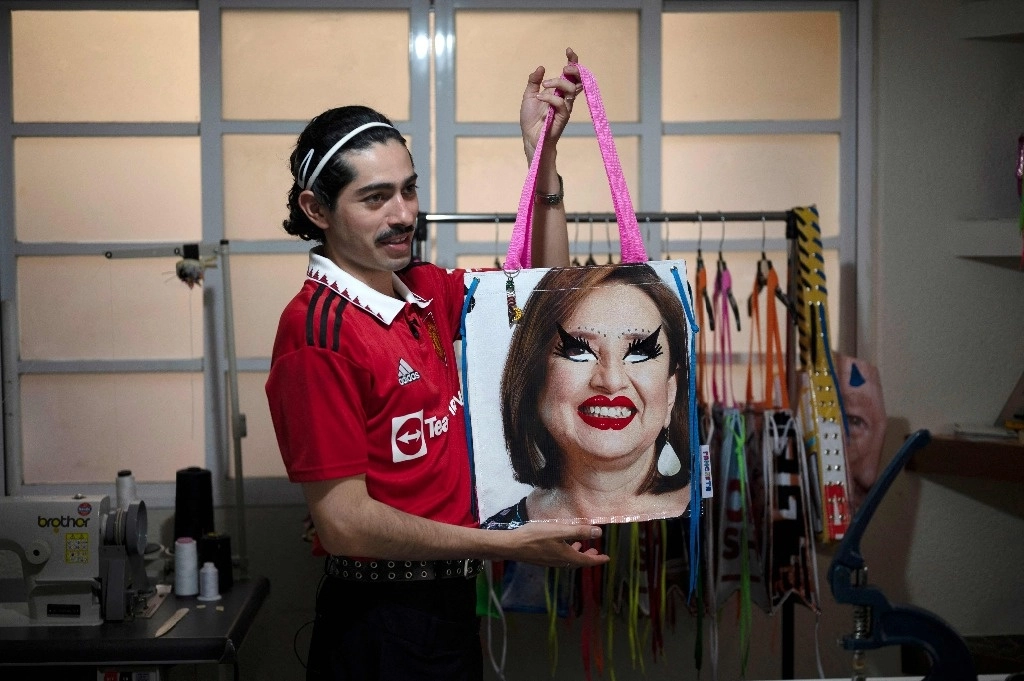Reciclando. El diseñador Misael Perea reutilizó material de propaganda electoral, como lonas y pancartas, para elaborar bolsos y gorras en la Ciudad de México. Foto Afp