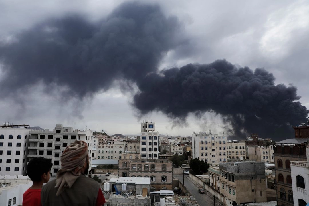 Los yemeníes observan cómo se elevan columnas de humo tras los ataques aéreos israelíes contra una central eléctrica y el aeropuerto de Saná, en Saná, Yemen, el 6 de mayo de 2025.