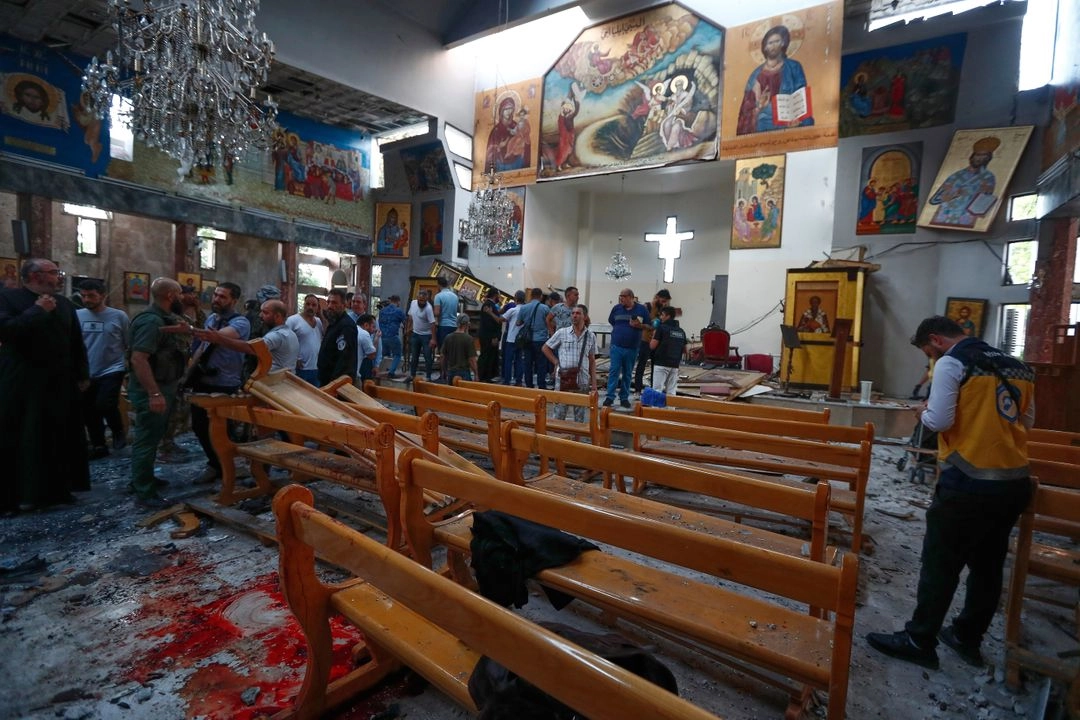 Sirios se reúnen dentro de la iglesia de Mar Elias, donde un atacante suicida se detonó en Dweil'a, en las afueras de Damasco, Siria, el 22 de junio de 2025.