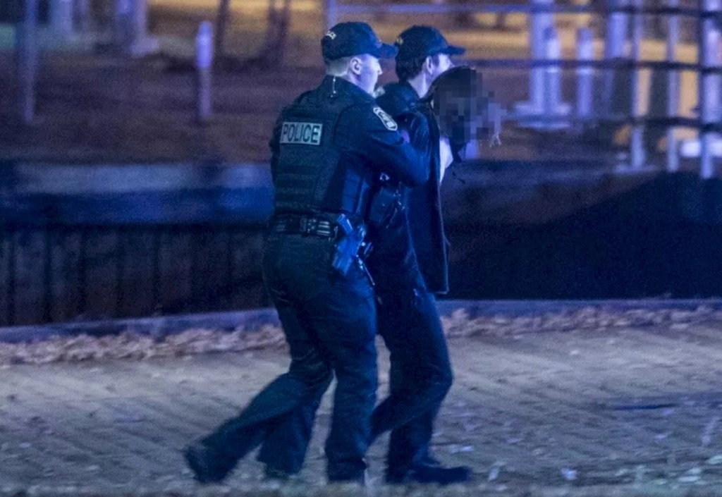 La policía conduce a un joven de 20 años, detenido como responsables del ataque a cuchilladas en Quebec, en la madrugada del 1 de noviembre de 2020. Foto Afp