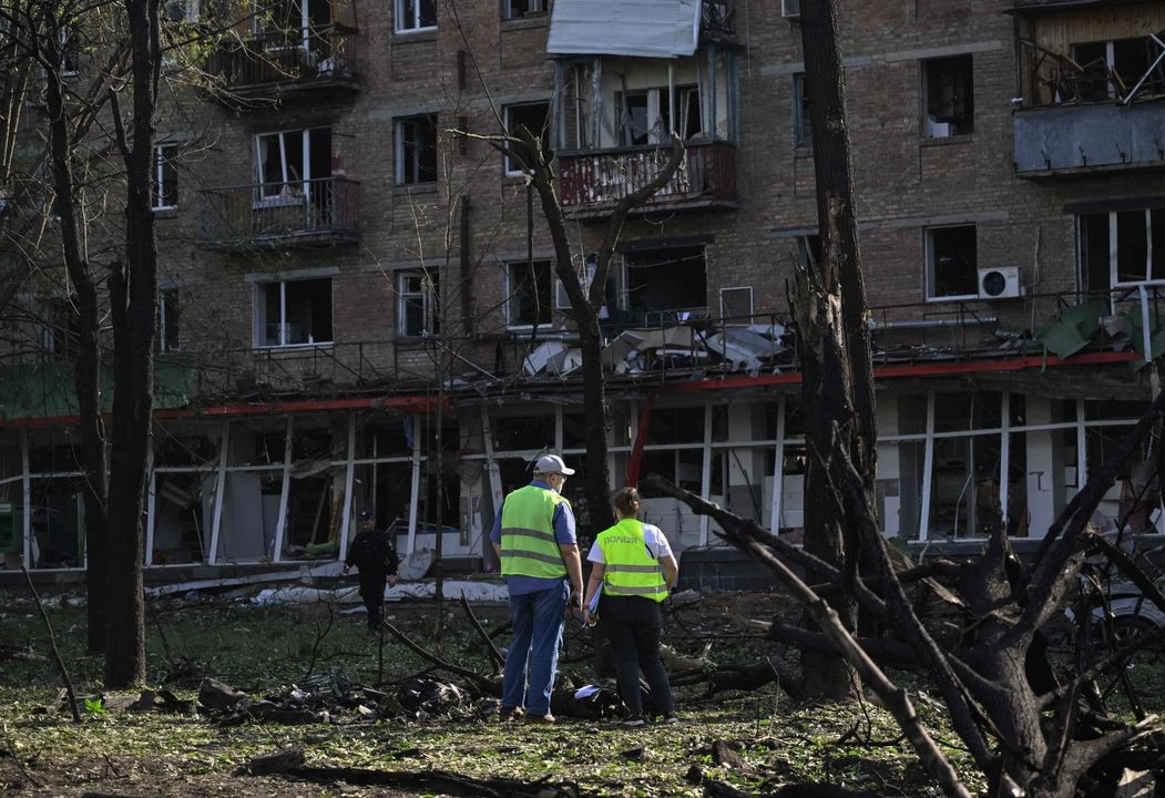 Agentes de policía trabajan en el lugar de un edificio residencial dañado tras un ataque con misiles y drones rusos en Kiev el 17 de junio de 2025, en medio de la invasión rusa de Ucrania. 