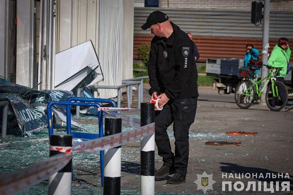 Un oficial de policía ucraniano trabaja en el lugar de un edificio dañado tras un ataque con misiles en Zaporizhzhia, en medio de la invasión rusa de Ucrania. Foto Afp