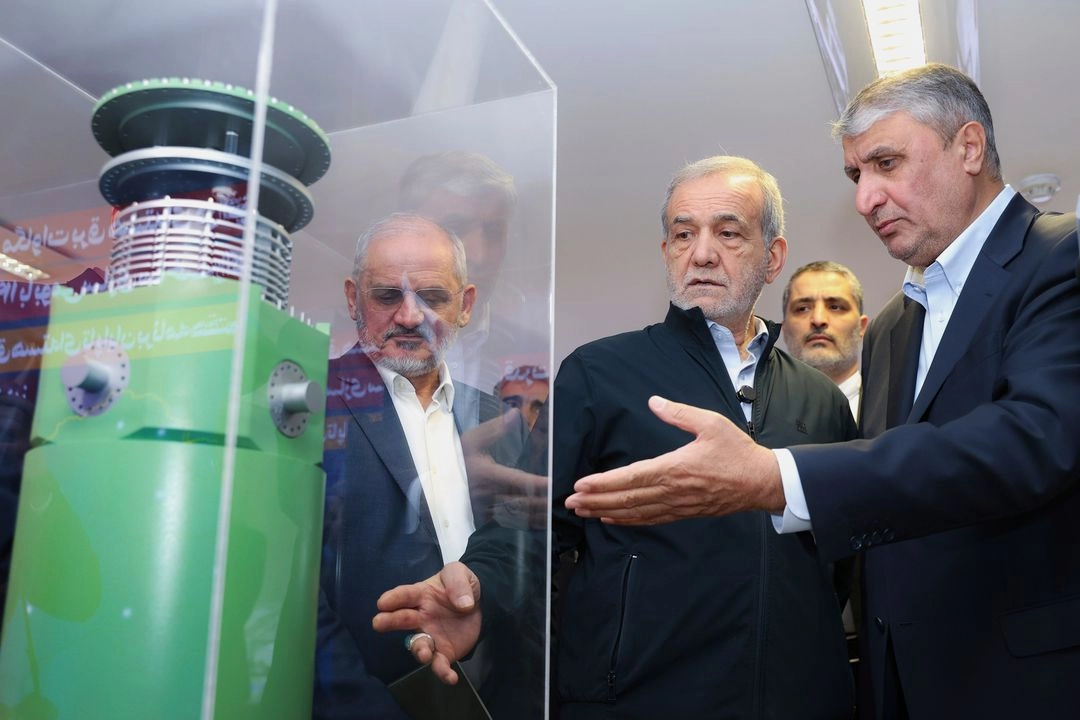 El presidente iraní, Masoud Pezeshkian (centro), escucha al jefe de la Organización de Energía Atómica de Irán, Mohamed Eslami, mientras visita una exposición de los logros nucleares de Irán, en Teherán, el 9 de abril de 2025. Foto 