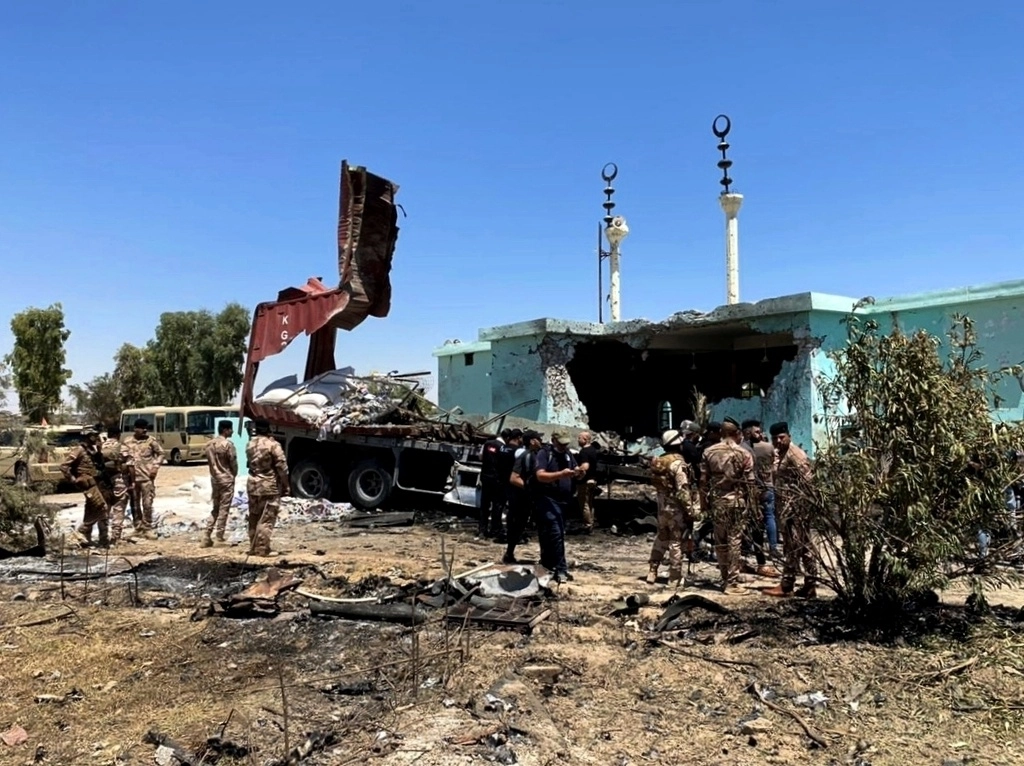 Fuerzas de seguridad se reúnen cerca de un camión que fue utilizado como lanzacohetes en Anbar, Irak. Foto Ap