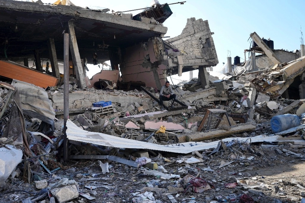 Un palestino se sienta entre la destrucción causada por el bombardeo israelí en el campo de refugiados de Nusseirat en la franja de Gaza, el 19 de enero de 2024. Foto Ap