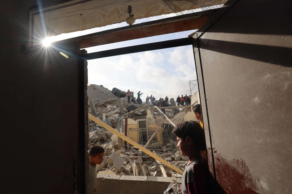 Palestinos inspeccionan los escombros de un edificio bombardeado por la noche por Israel, en Rafah, al sur de la franja de Gaza. Foto Afp