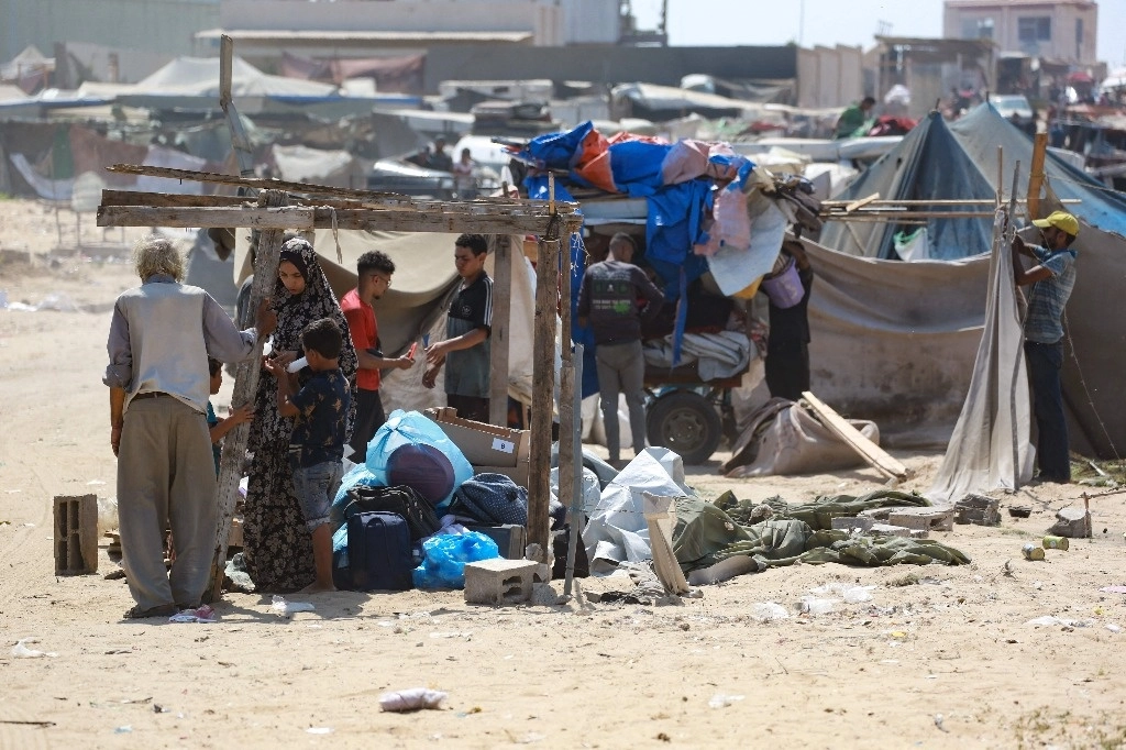Palestinos recogen sus pertenencias de un campamento improvisado para personas desplazadas en Yan Junis, al sur de la franja de Gaza, el 18 de agosto de 2024. Foto Afp