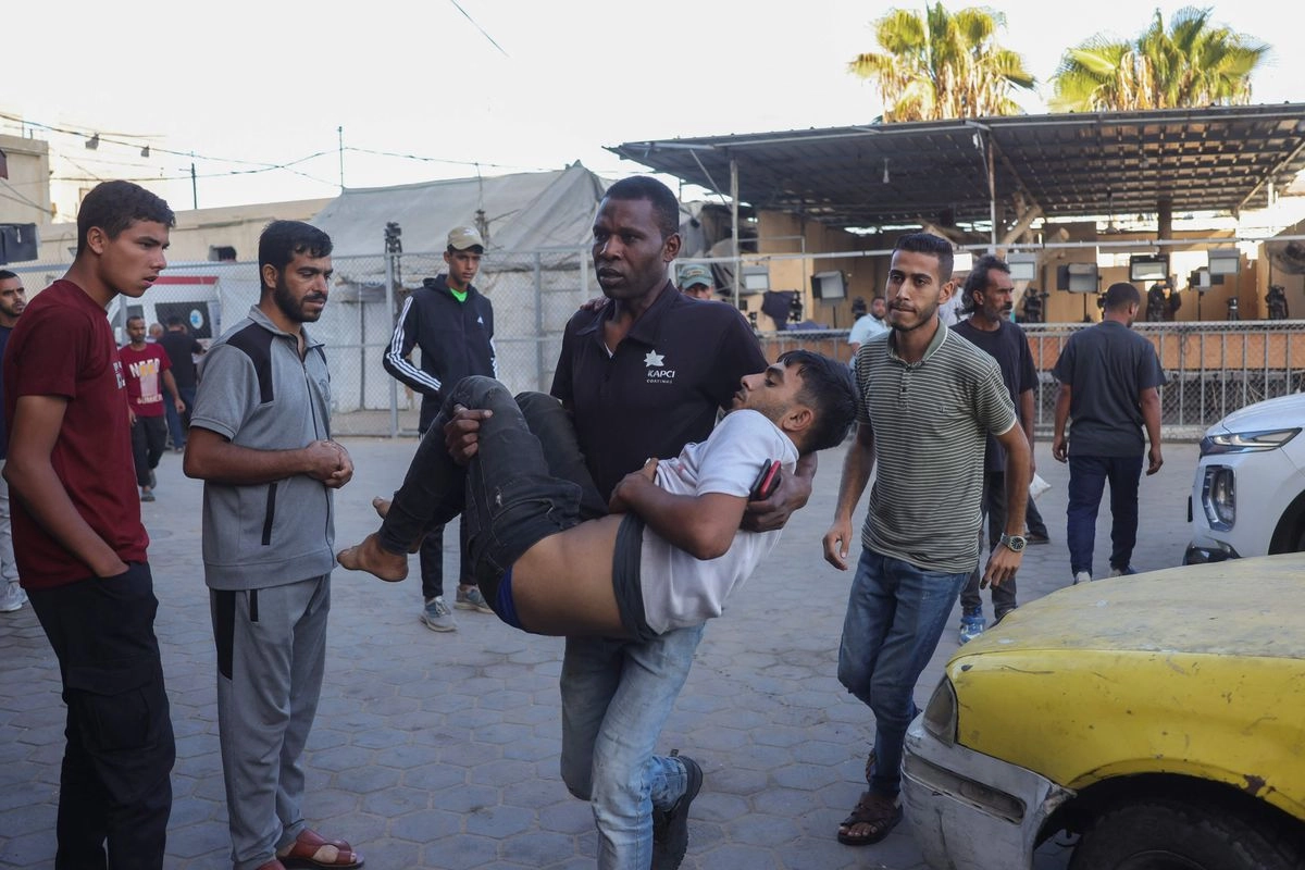 Un hombre palestino lleva a un joven herido al Hospital de Al-Aqsa, en la ciudad de Deir al-Balah, en el centro de la franja de Gaza, el 2 de octubre de 2025. Foto 
