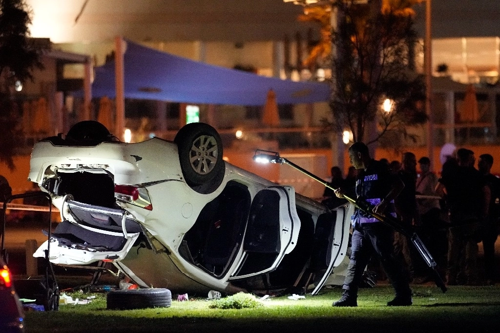 La policía y los servicios de emergencia israelíes trabajan alrededor de un automóvil involucrado en un ataque en Tel Aviv, el 7 de abril de 2023. Foto Ap