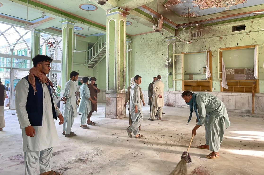 Hombres afganos inspeccionan los daños dentro de una mezquita chií en Kandahar tras un ataque suicida con bomba, el 15 de octubre de 2021. Foto Afp