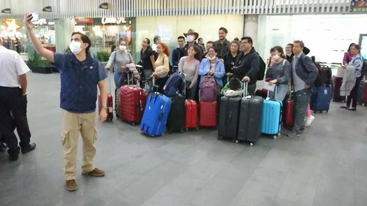 Mexicanos provenientes de Perú se toman una fotografía a su llegada al AICM. Foto César Arellano