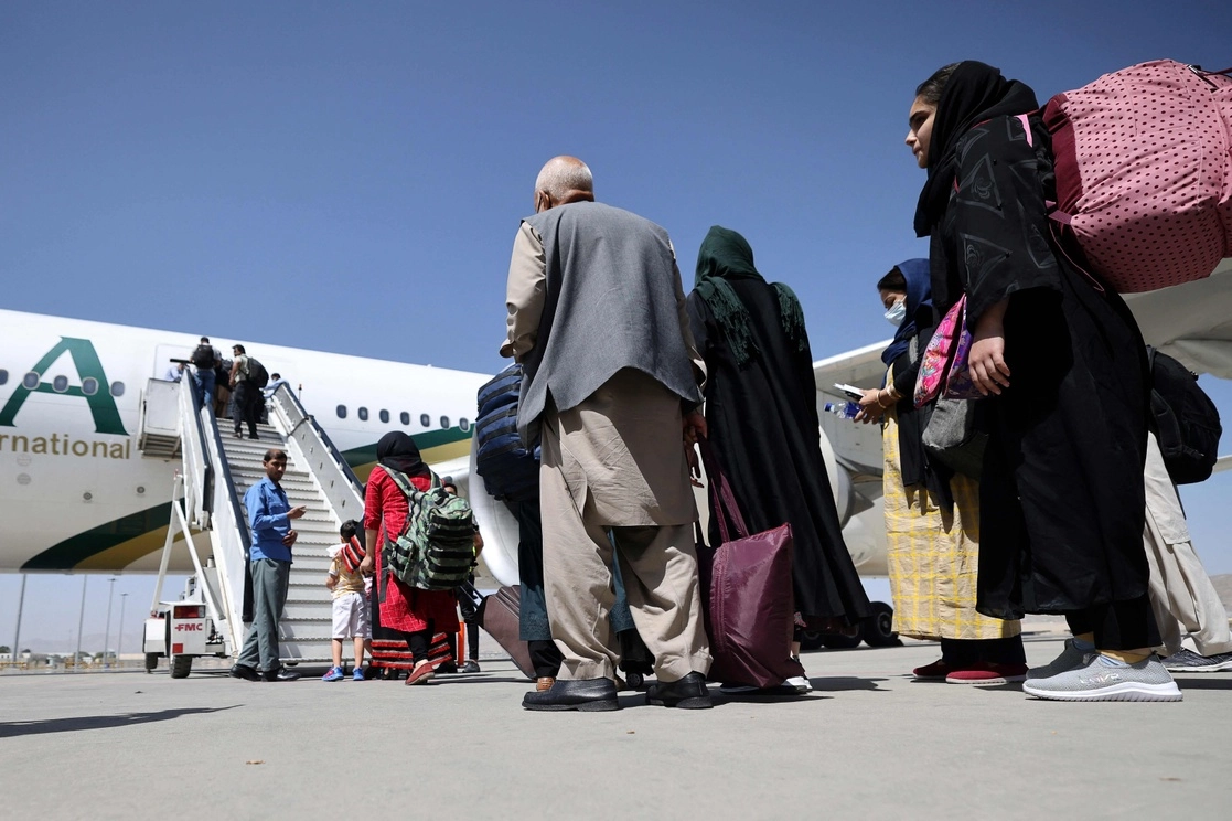 Pasajeros abordan un avión de la compañía paquistaní PIA, el 13 de septiembre de 2021. Éste es el primer vuelo comercial internacional desde que los talibanes tomaron el poder en Afganistán el 15 de agosto pasado. Foto Afp 