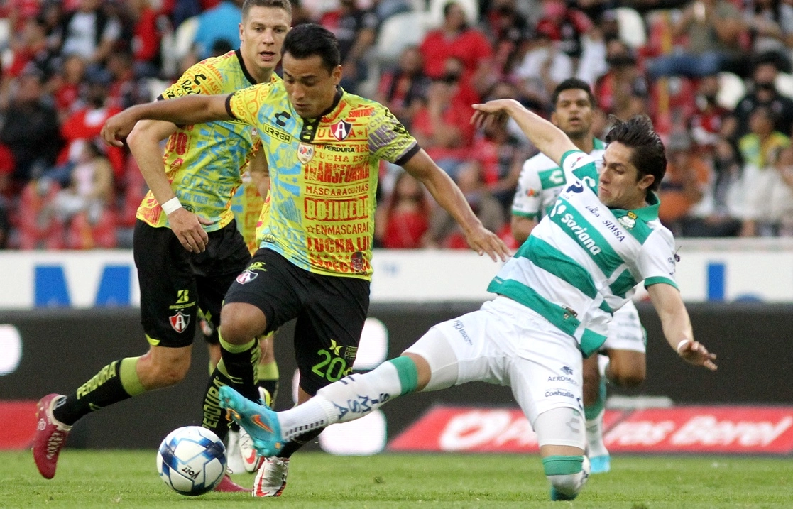 Ian Torres pelea el balón con Alan Cervantes durante el encuentro Atlas-Santos, en el estadio Jalisco. Foto Afp