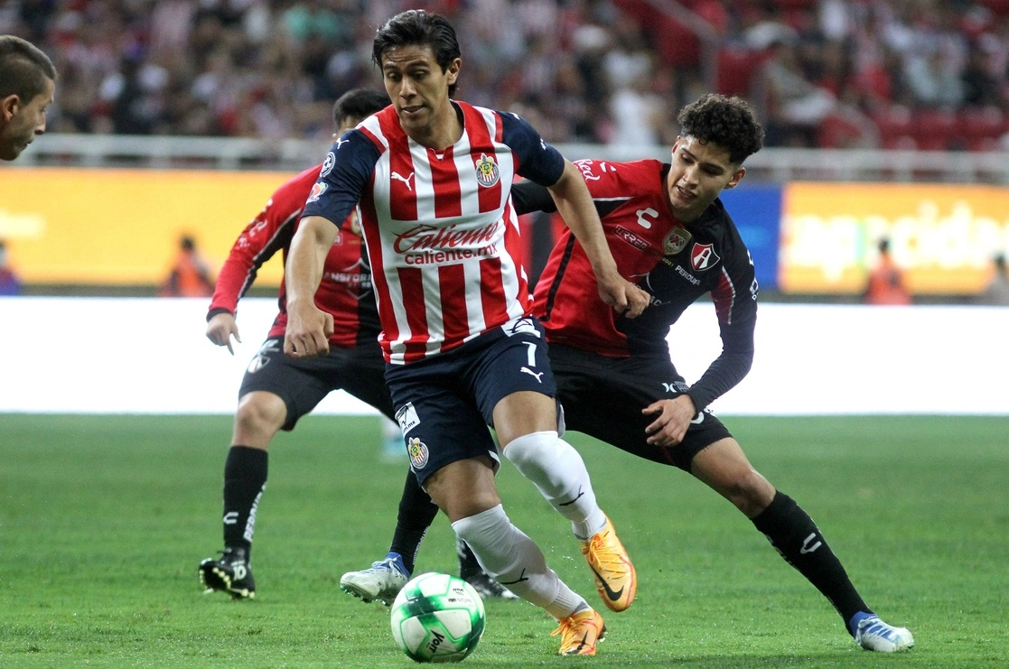 José Juan Macías del Guadalajara disputa el esférico con Ángel Márquez del Atlas. Foto Afp