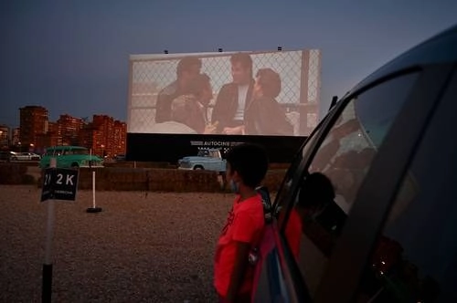 Los autocinemas en Brasil y España son ahora una forma de distracción segura para huir de las restricciones por la pandemia de Covid-19; en la imagen, la proyección en Madrid de "Vaselina". Foto Afp
