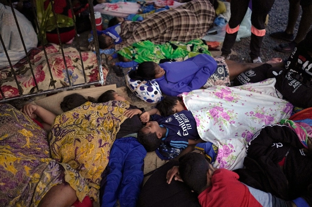 Jóvenes venezolanos esperan para ingresar a un albergue en Pacaraima, Brasil. Foto Ap